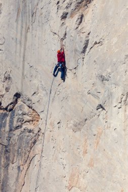 Bir adam kaya tırmanıyor.