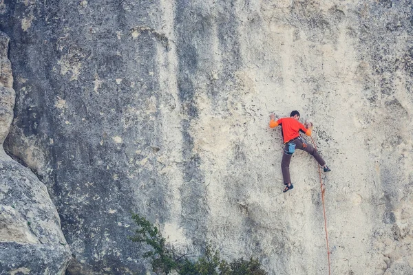 Un hombre sube a la roca . — Foto de Stock