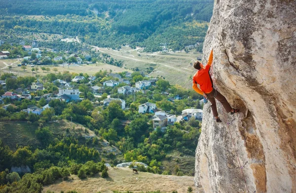 Um alpinista com um chapéu numa rocha . — Fotografia de Stock