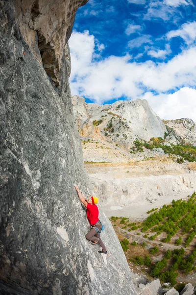 Un escalador en un sombrero en una roca . — Foto de Stock