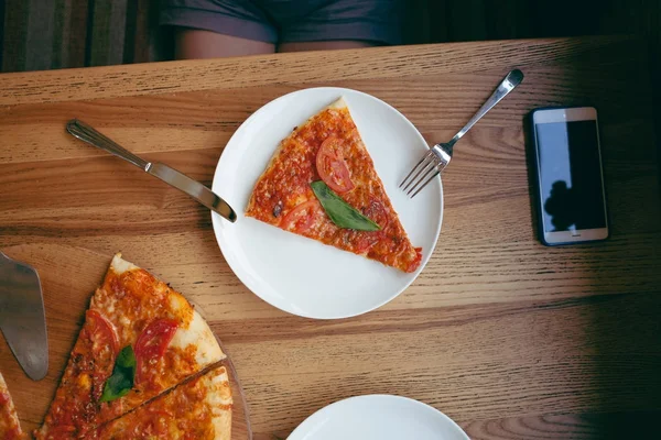 A slice of pizza on a plate.