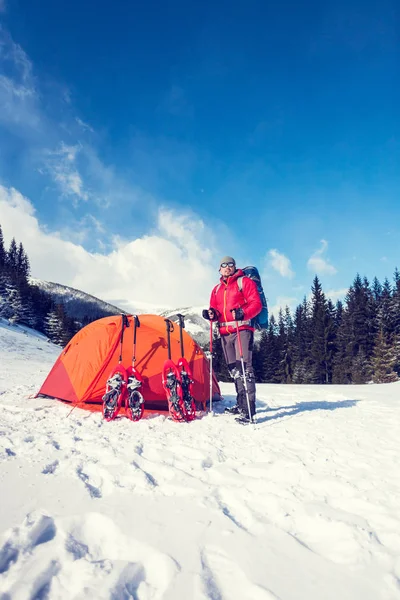 Escalador perto da tenda com sapatos de neve . — Fotografia de Stock