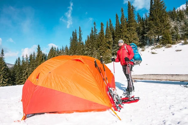 Escalador perto da tenda com sapatos de neve . — Fotografia de Stock