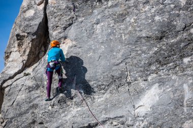 The girl climbs the rock. clipart