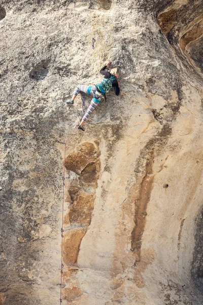 Het meisje klimt de rots. — Stockfoto