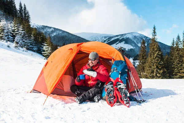 Ein Mann in der Nähe eines Zeltes im Winter. — Stockfoto