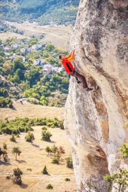 Bir dağcı bir kayanın üzerinde.