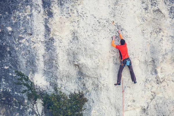 Un hombre sube a la roca . — Foto de Stock