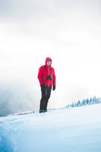 Um homem de sapatos de neve tira fotos de montanhas . — Fotografia de Stock