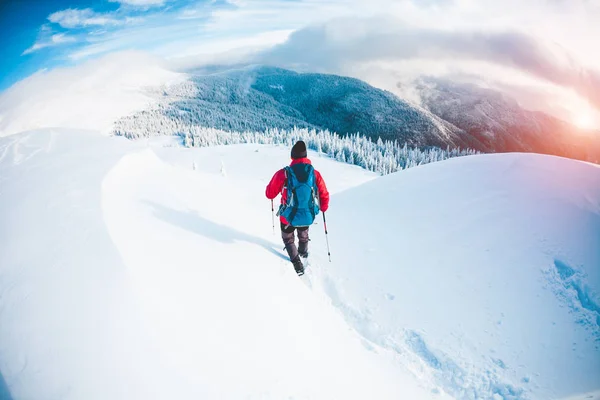Ένας άνθρωπος με χιονοπέδιλα στα βουνά το χειμώνα. — Φωτογραφία Αρχείου