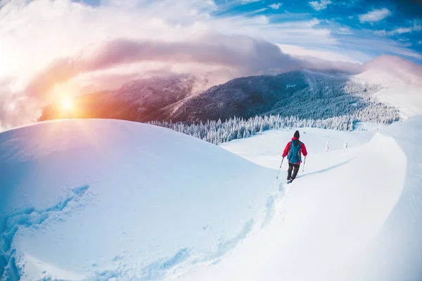 Un homme en raquettes dans les montagnes en hiver . — Photo