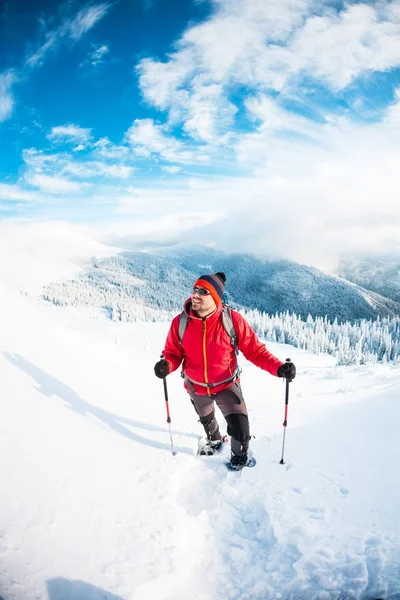 Un homme en raquettes dans les montagnes en hiver . — Photo