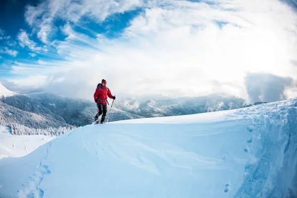 Un homme en raquettes dans les montagnes en hiver . — Photo
