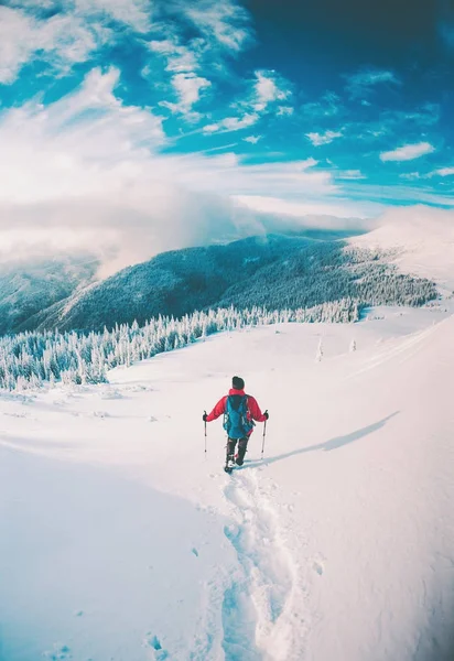 Um homem de sapatos de neve nas montanhas no inverno . — Fotografia de Stock