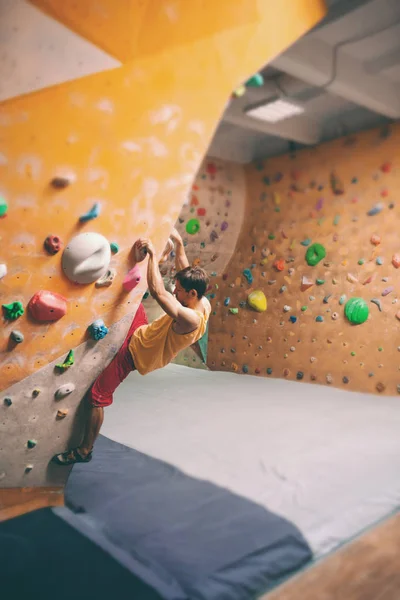 Skalisty arywista jest w hali bouldering. — Zdjęcie stockowe