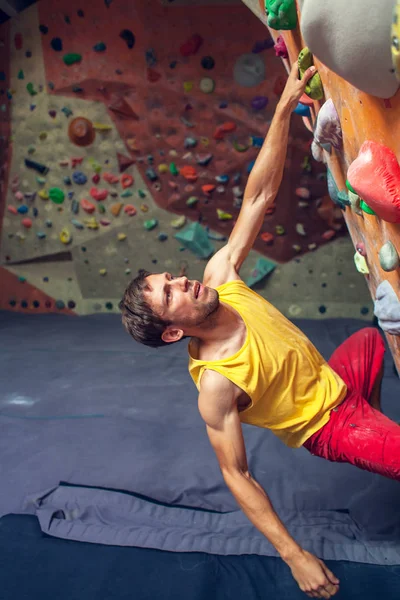 Ροκ ορειβάτης που είναι σε μια αίθουσα bouldering. — Φωτογραφία Αρχείου