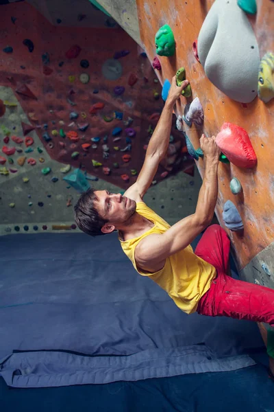 Skalisty arywista jest w hali bouldering. — Zdjęcie stockowe