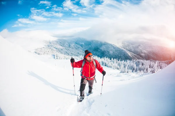 Ein Mann in Schneeschuhen in den Bergen. — Stockfoto