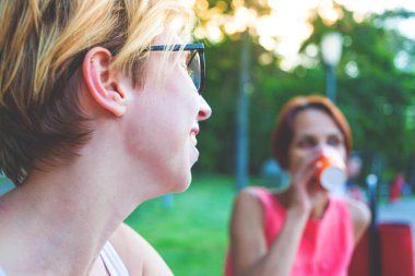 İki kadın parkta konuşuyor.