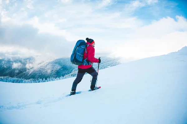 Seorang pria dengan sepatu salju di pegunungan . — Stok Foto