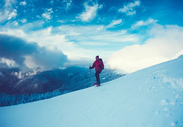 En man i snöskor i bergen. — Stockfoto