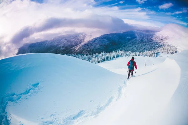 Ένας άνθρωπος με χιονοπέδιλα στα βουνά το χειμώνα. — Φωτογραφία Αρχείου