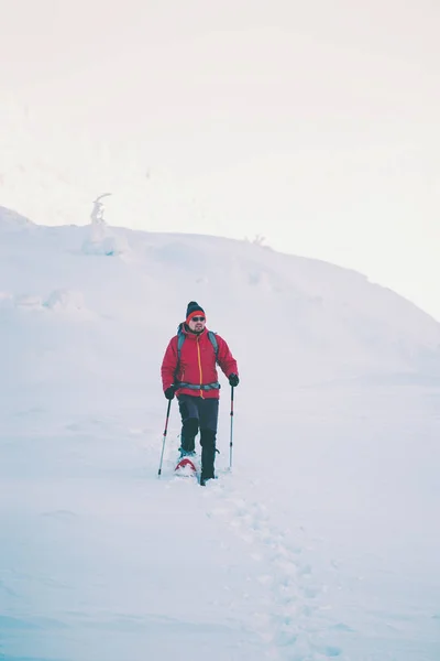 Um homem de sapatos de neve nas montanhas . — Fotografia de Stock