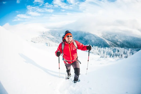 Un homme en raquettes dans les montagnes . — Photo