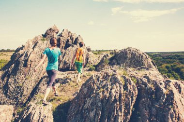 Kızlar bir sırt çantası ile pitoresk yerlerde yürümek.