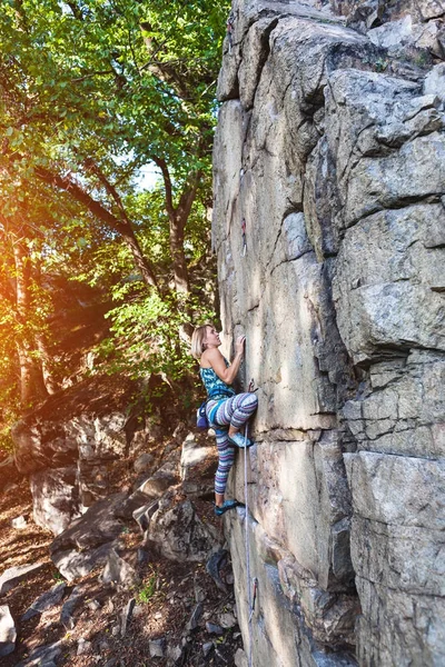 Chica escalador en una roca . — Foto de Stock