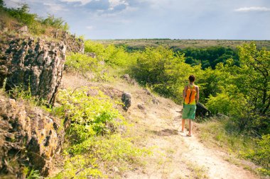 Kız bir sırt çantası ile pitoresk yerlerde yürümek.