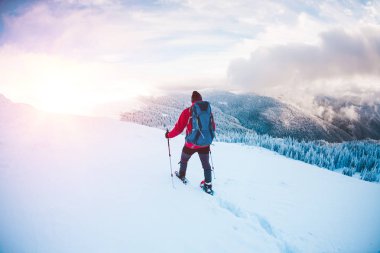 Bir erkekte dağlarda kar ayakkabıları.