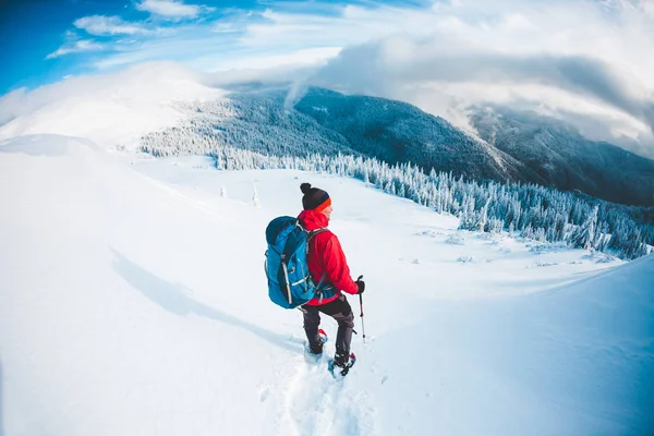 Um homem de sapatos de neve nas montanhas no inverno . — Fotografia de Stock