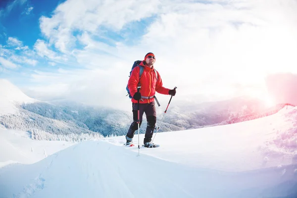 Un homme en raquettes dans les montagnes en hiver . — Photo