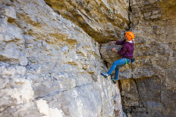 La mujer en el casco sube a la roca . — Foto de Stock