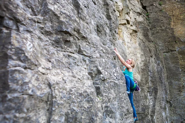 Une femme grimpeuse sur un rocher . — Photo