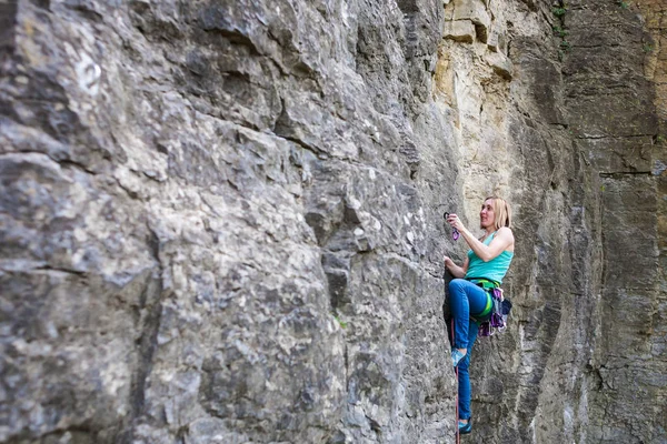 Uma mulher alpinista numa rocha . — Fotografia de Stock