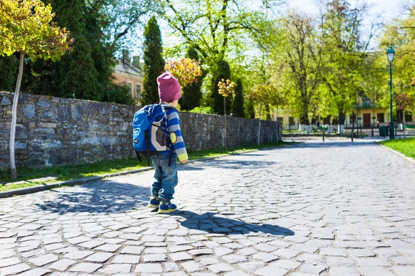 Ein Junge mit Rucksack läuft über die Straße. — Stockfoto