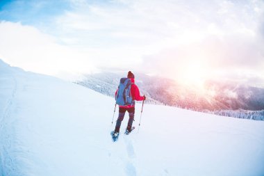 Bir erkekte dağlarda kar ayakkabıları.