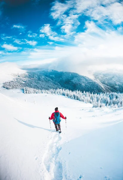 Un homme en raquettes dans les montagnes en hiver . — Photo