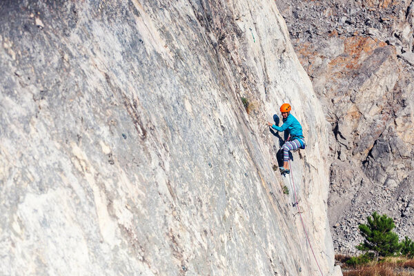 The girl climbs the rock.