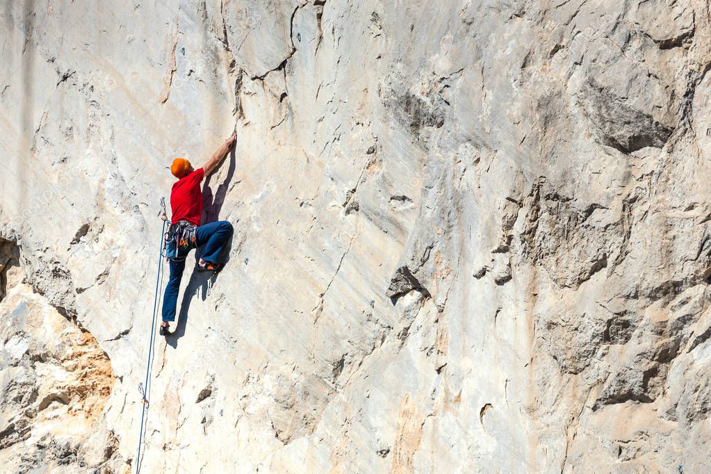 A man is training to climb on a rock.