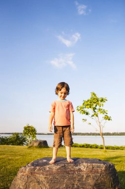 Çocuk taş üzerine tırmandı.