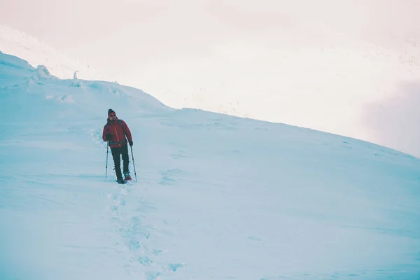 Um homem de sapatos de neve nas montanhas . — Fotografia de Stock