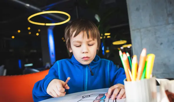 Der Junge zeichnet mit Bleistiften. — Stockfoto