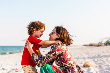 Çocuk ile anne sahilde.