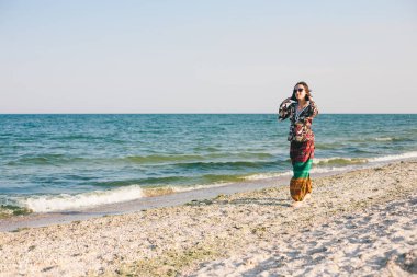 Bir kız sahilde yürüyor.