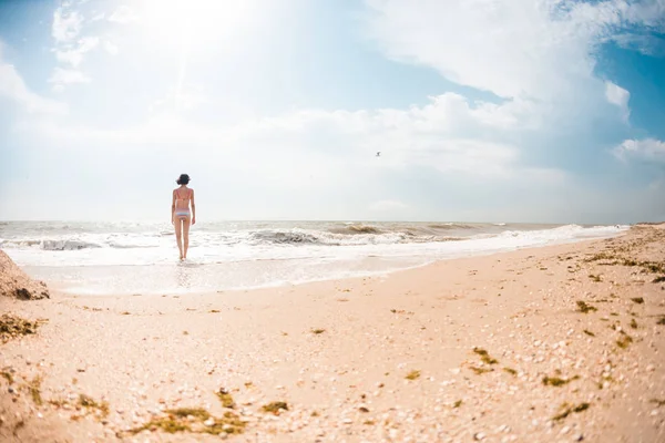 Una ragazza cammina lungo la spiaggia . — Foto Stock