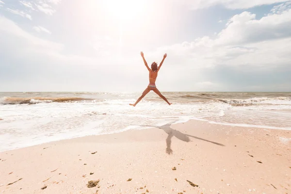 Een meisje is springen op het strand. — Stockfoto