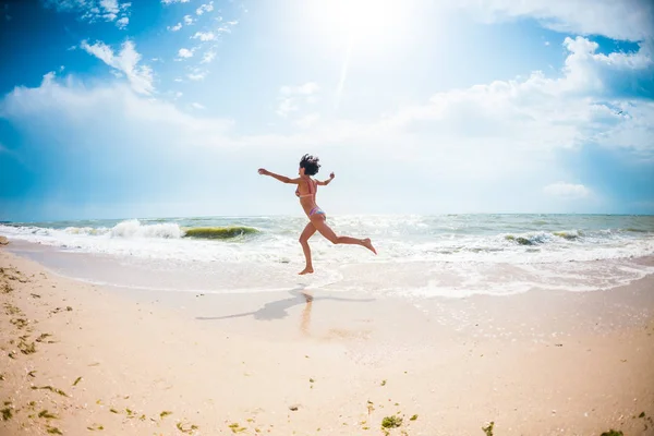 Een meisje is springen op het strand. — Stockfoto